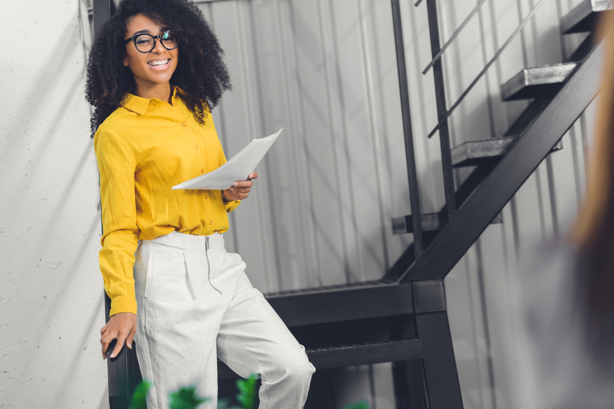 beautiful african american businesswoman holding papers and smiling at camera in office beautiful african american businesswoman holding papers and smiling at camera in office